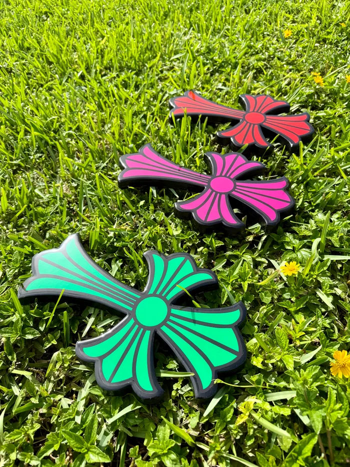 A row of coloured epoxy crosses laid out on grass